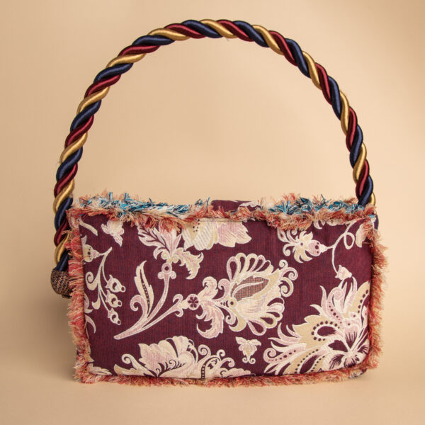 Dettaglio del retro della borsa Carmen reverse da donna in cotone e poliestere color bordeaux con decorazioni floreali chiare